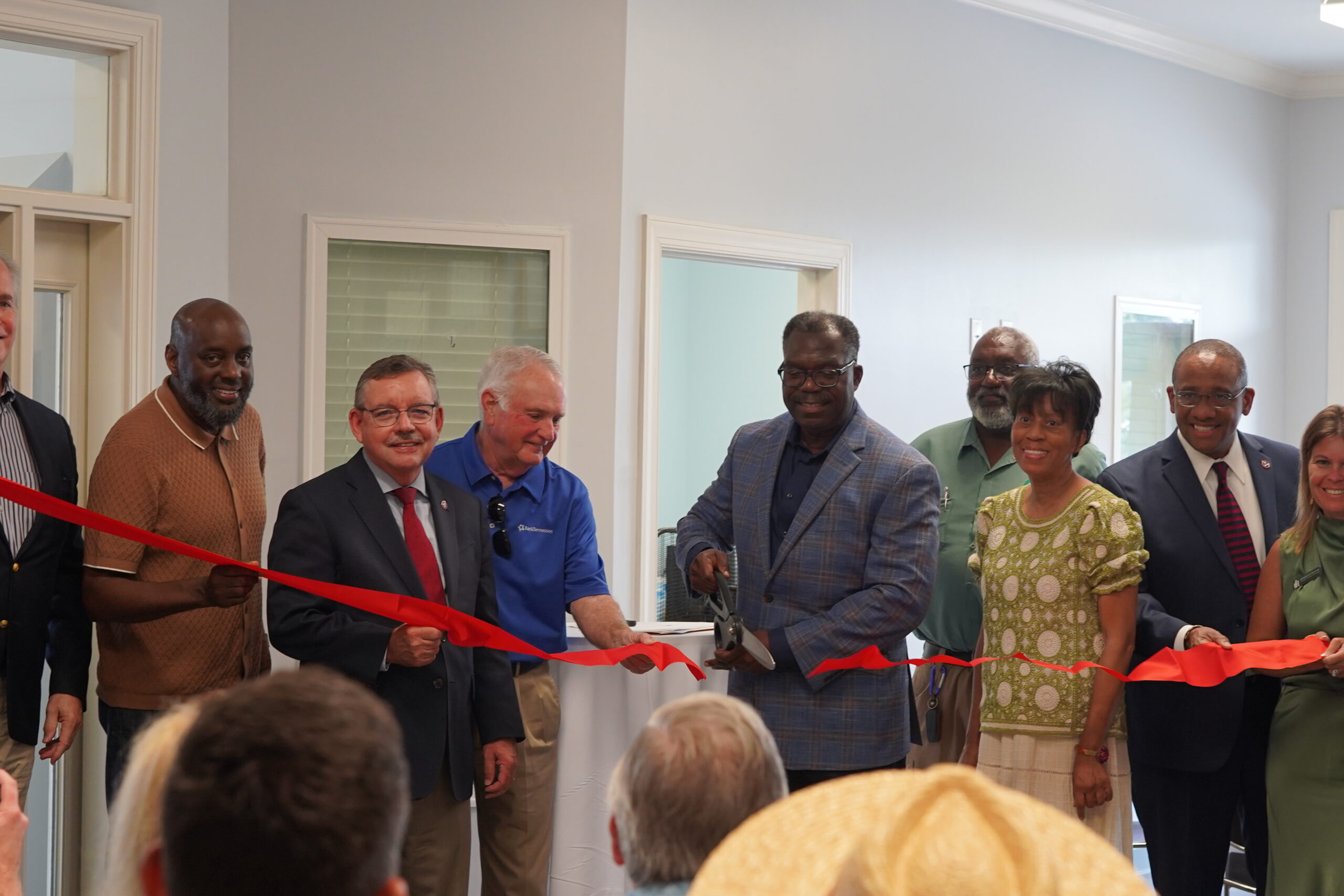 people standing cutting ribbon