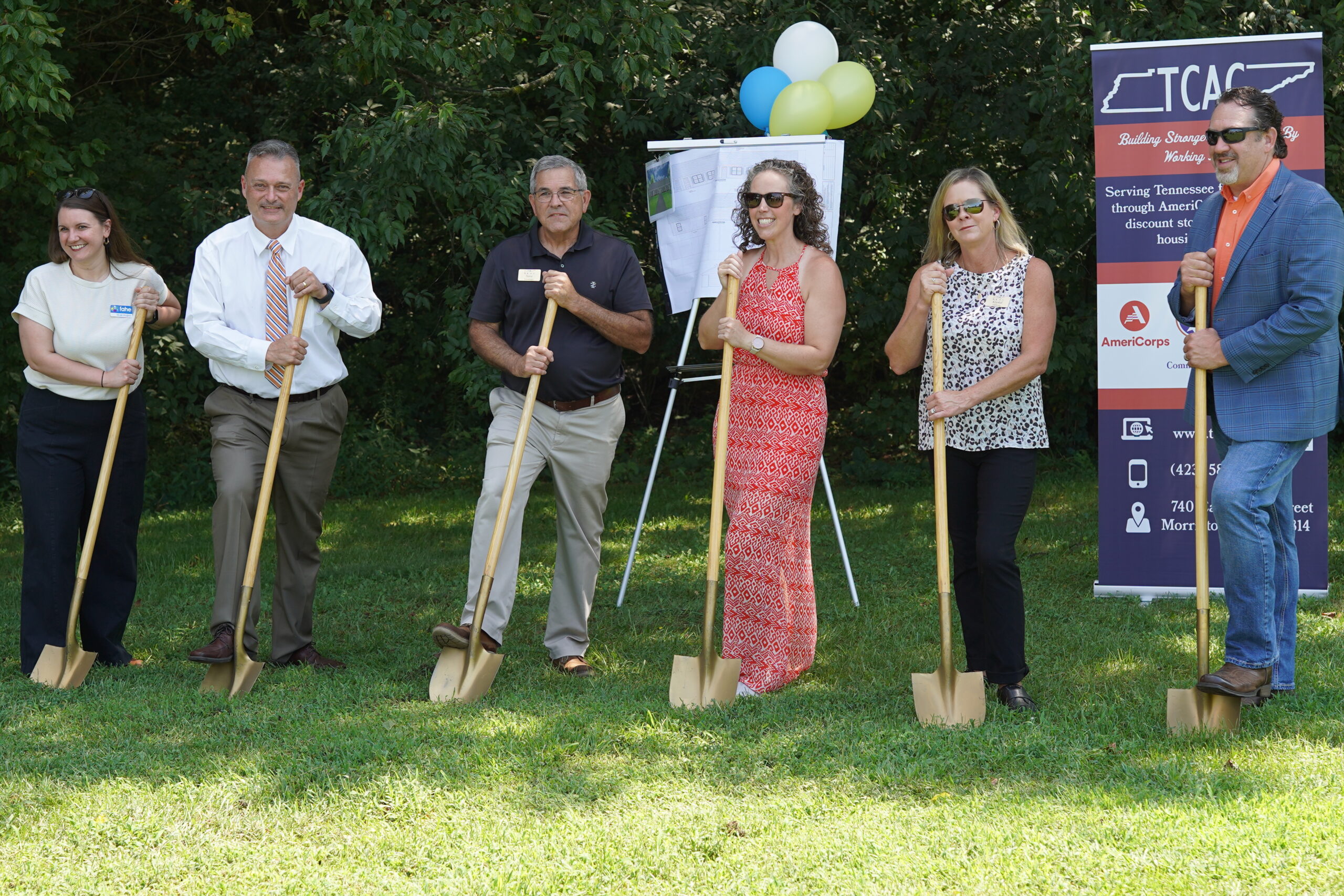 people standing holding shovels